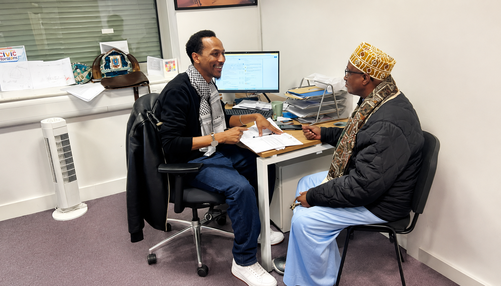 Two people in discussion across a desk